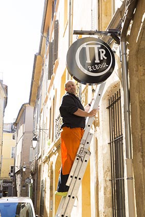 Pierre Reboul et son enseigne © Maurice Rougemont